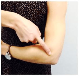 Person pointing to a bone in their elbow